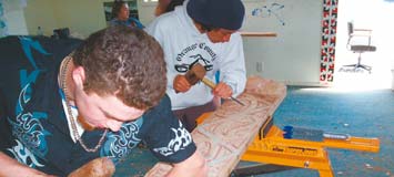 Young Maori doing carving